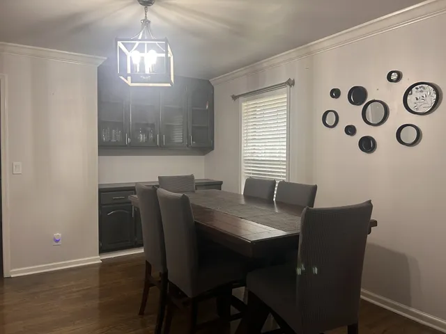 a kitchen with a table chairs refrigerator and microwave