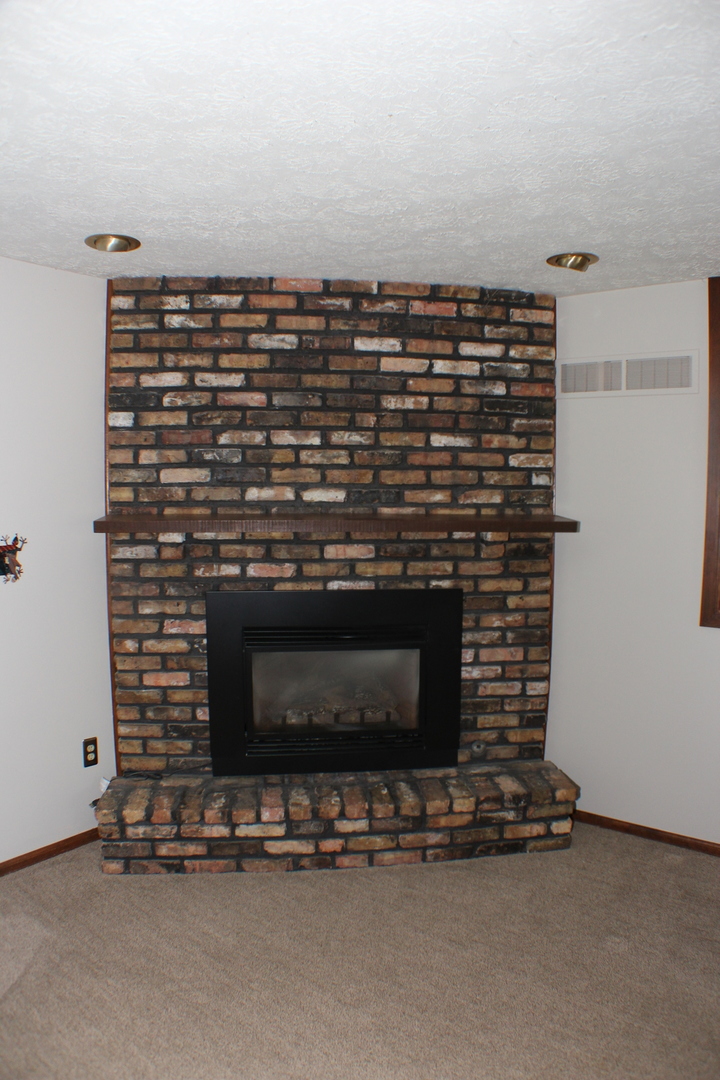 8 Apache Court Eldridge, IA 52748 - Photo 8 of 29 a view of a fireplace with wooden floor