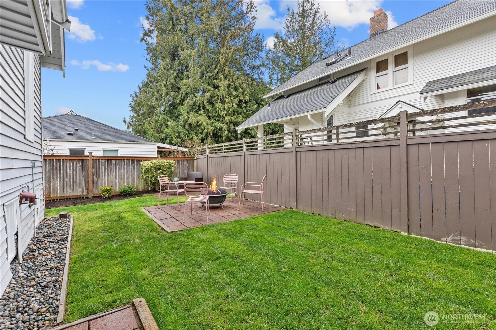 2857 Northwest 73rd Street Seattle, WA 98117 - Photo 16 of 25 a view of a backyard with table and chairs and wooden fence