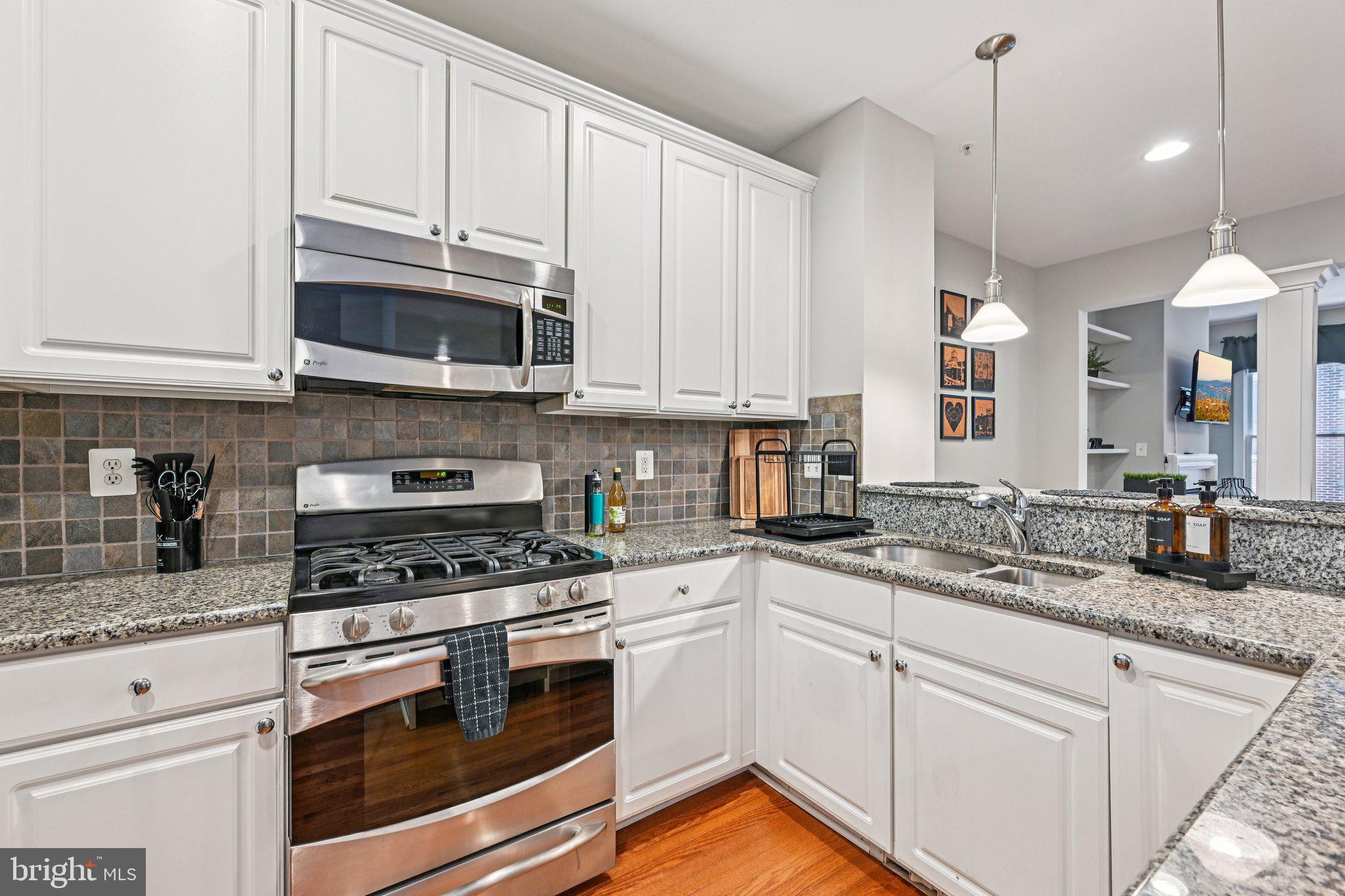 24 South Regester Street Baltimore, MD 21231 - Photo 5 of 44 a kitchen with granite countertop white cabinets stainless steel appliances and a sink