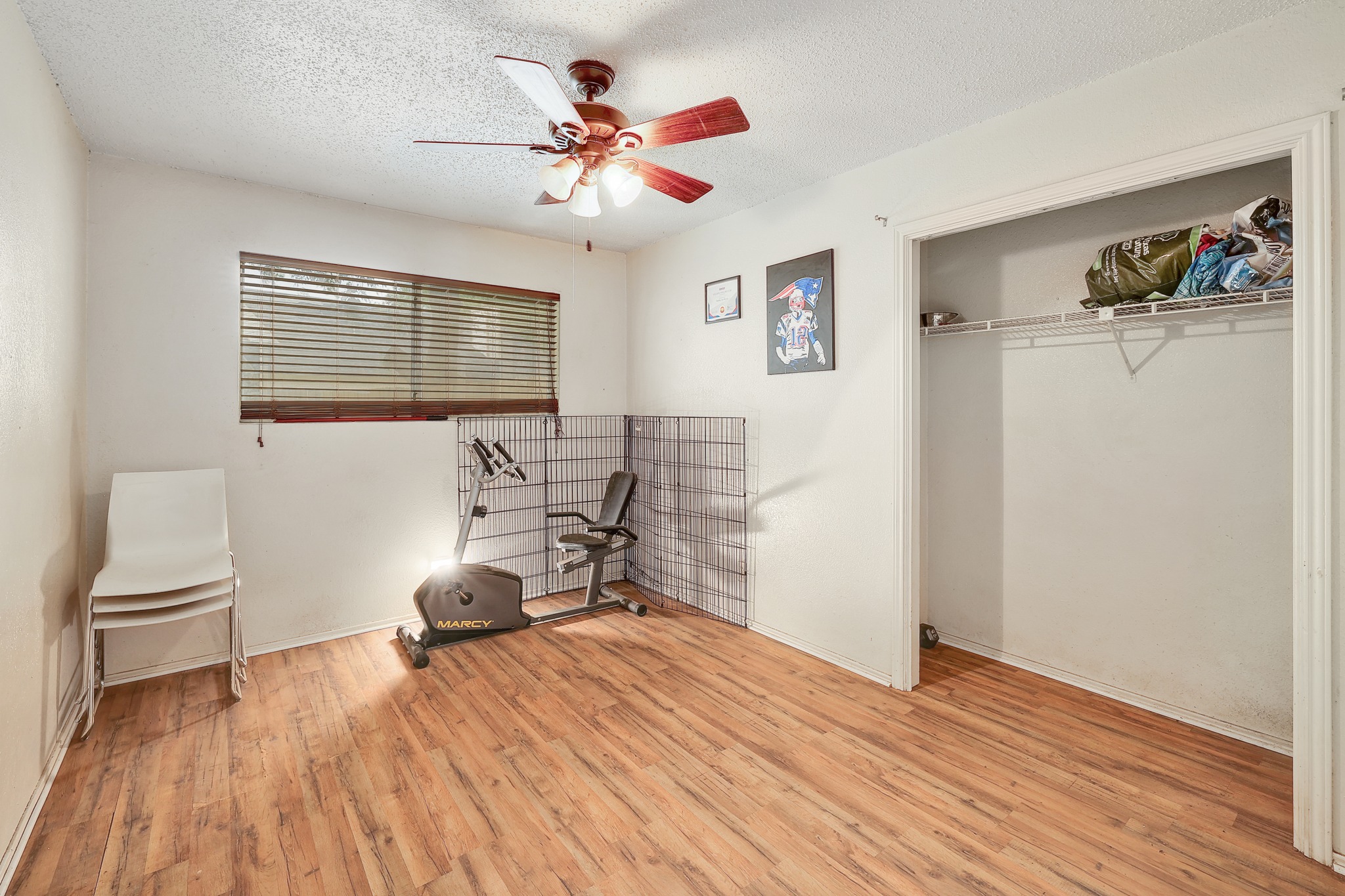 9901 Parliament House Road Austin, TX 78729 - Photo 14 of 40 Bedroom featuring light wood-style flooring, a textured ceiling, a closet, and ceiling fan