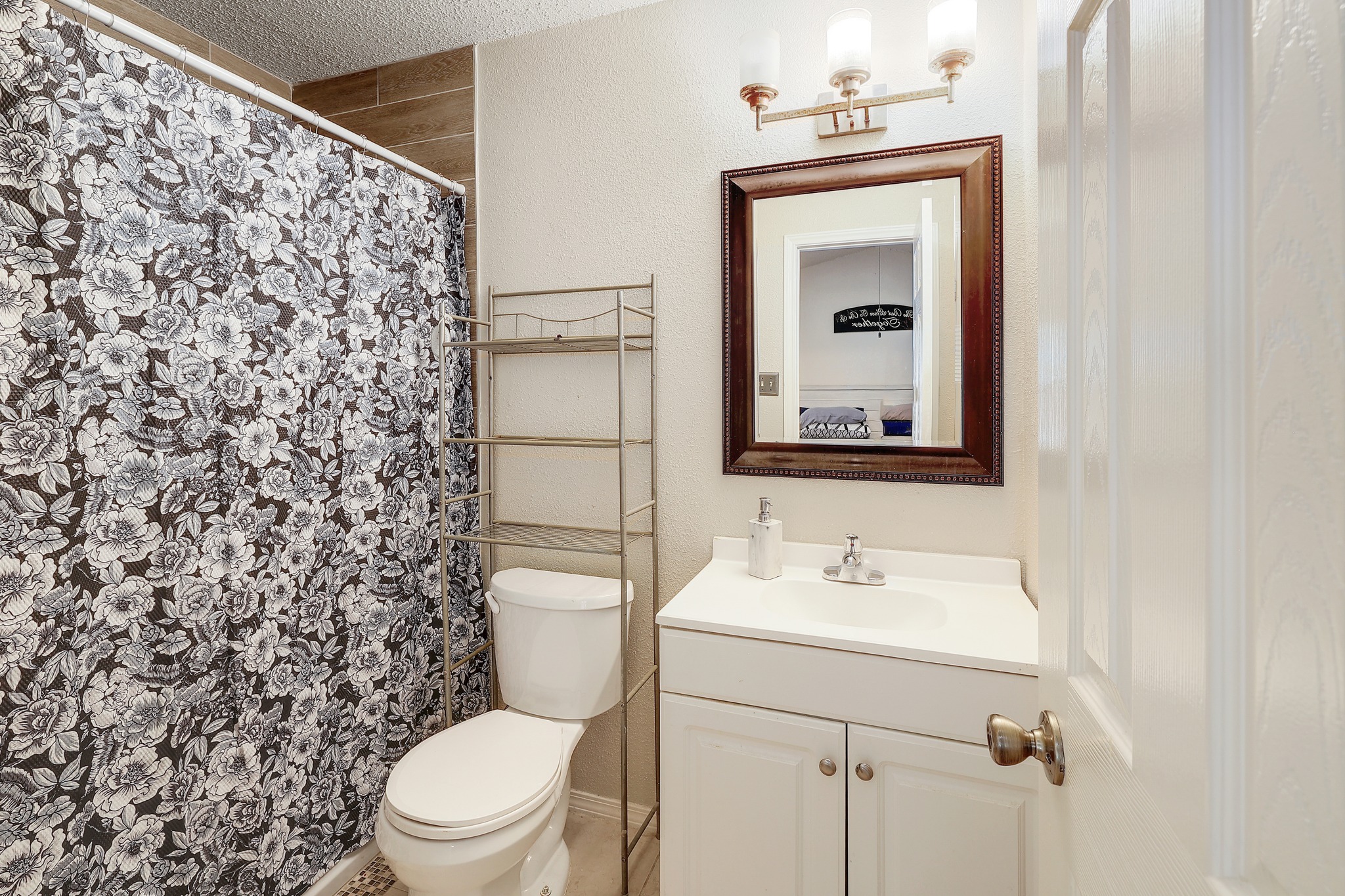 9901 Parliament House Road Austin, TX 78729 - Photo 15 of 40 Full bath with vanity, curtained shower, and a textured wall