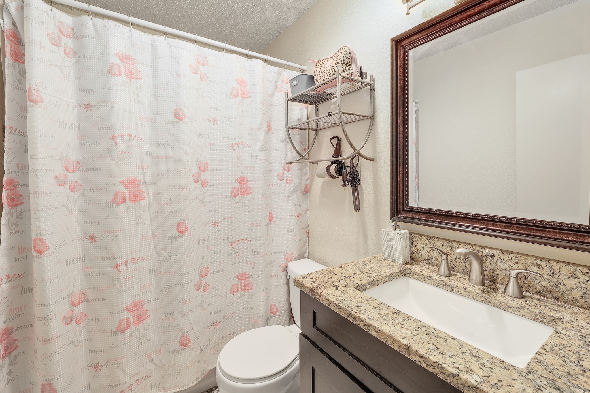 9901 Parliament House Road Austin, TX 78729 - Photo 16 of 40 Bathroom with vanity, a shower with curtain, and a textured ceiling