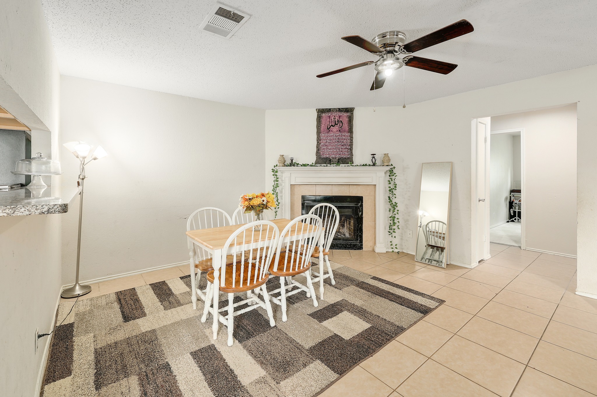 9901 Parliament House Road Austin, TX 78729 - Photo 18 of 40 Dining area with light tile patterned flooring, ceiling fan, and a tile fireplace
