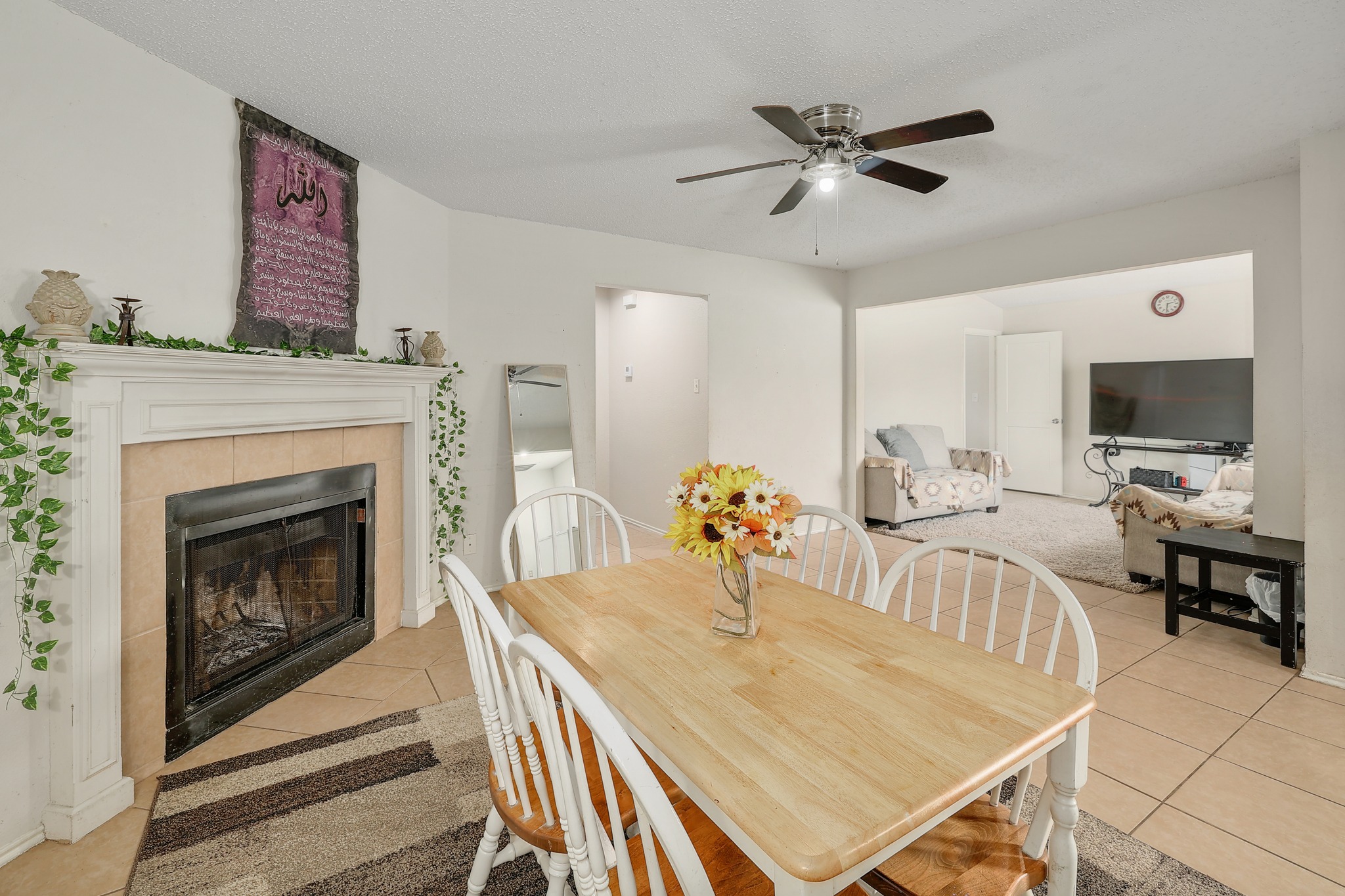 9901 Parliament House Road Austin, TX 78729 - Photo 19 of 40 Dining area with light tile patterned flooring, a tiled fireplace, and ceiling fan