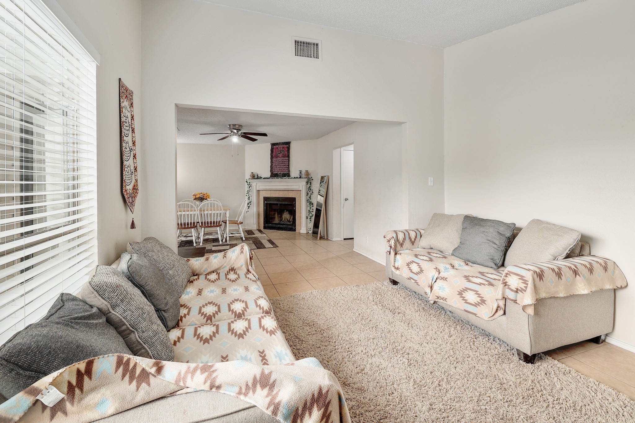 9901 Parliament House Road Austin, TX 78729 - Photo 24 of 40 Living area with light tile patterned flooring, a fireplace, and a ceiling fan