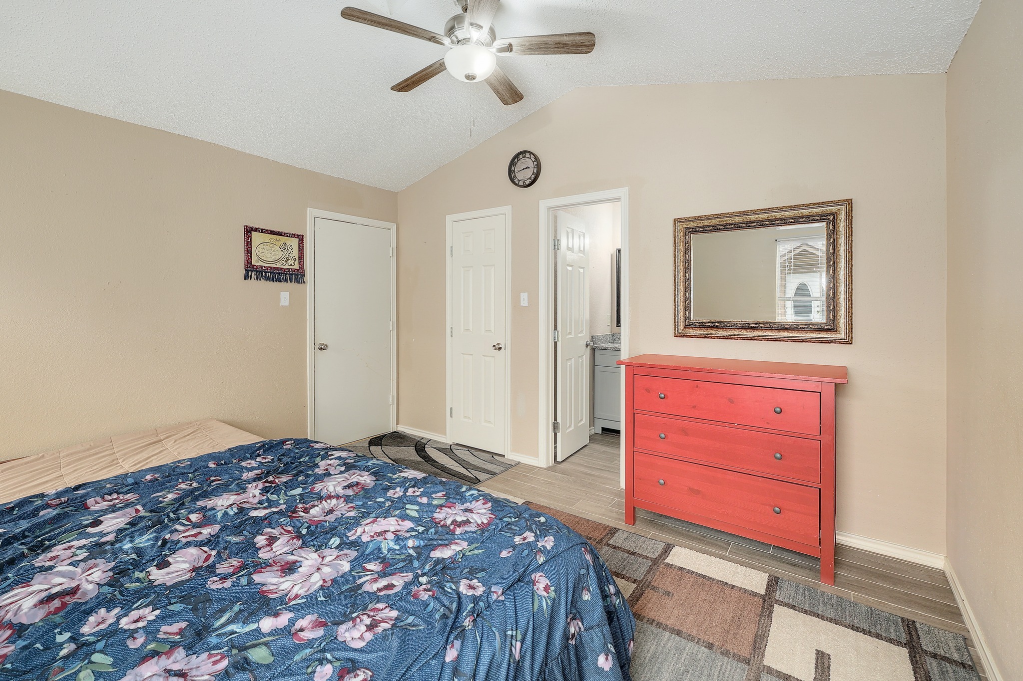 9901 Parliament House Road Austin, TX 78729 - Photo 29 of 40 Bedroom with light wood-type flooring, lofted ceiling, ceiling fan, and connected bathroom