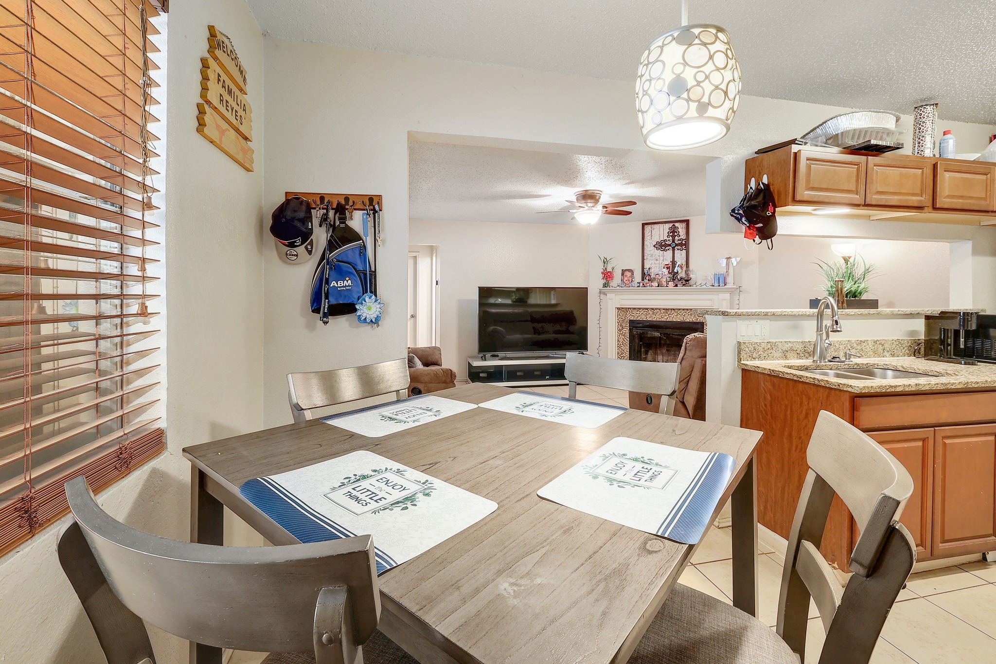 9901 Parliament House Road Austin, TX 78729 - Photo 10 of 40 Dining area with a glass covered fireplace, ceiling fan, and light tile patterned floors