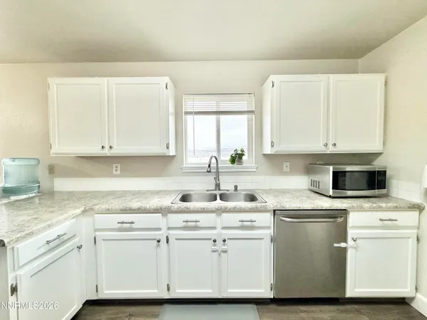 a kitchen with cabinets appliances a sink and a counter top