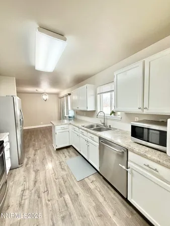a kitchen with white cabinets and white appliances