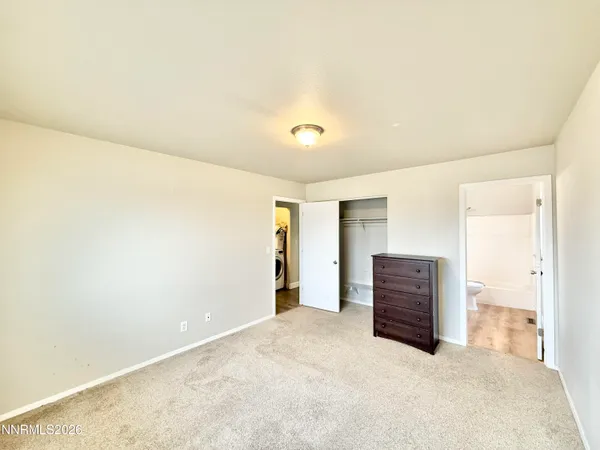 an empty room with closet and entryway