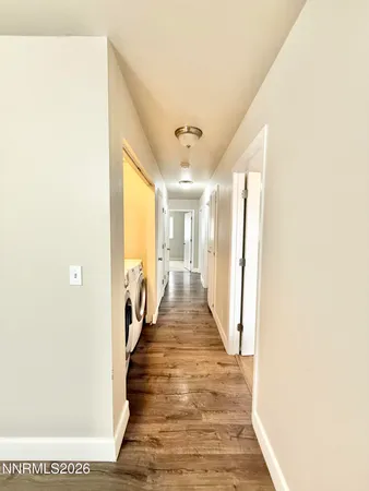 a view of a hallway with wooden floor and staircase