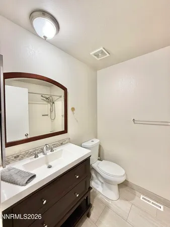 a bathroom with a sink a toilet and mirror