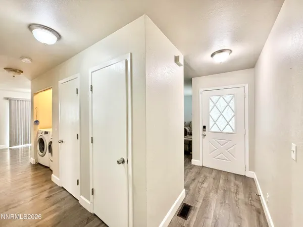 a view of a hallway with wooden floor and closet area