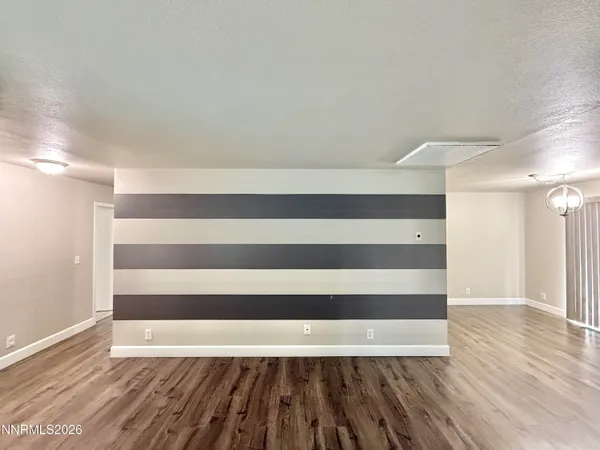 a view of a room with wooden floor and a window