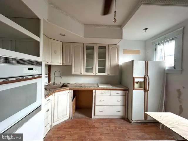 a kitchen with granite countertop a refrigerator stove top oven and sink