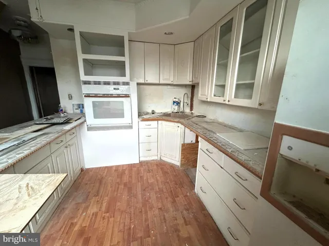 a kitchen with granite countertop a sink wooden floor and stainless steel appliances