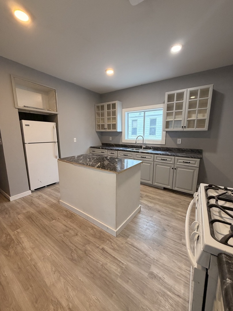 1024 South Warren Street Peoria, IL 61605 - Photo 1 of 14 a kitchen with granite countertop cabinets a sink a window and stainless steel appliances