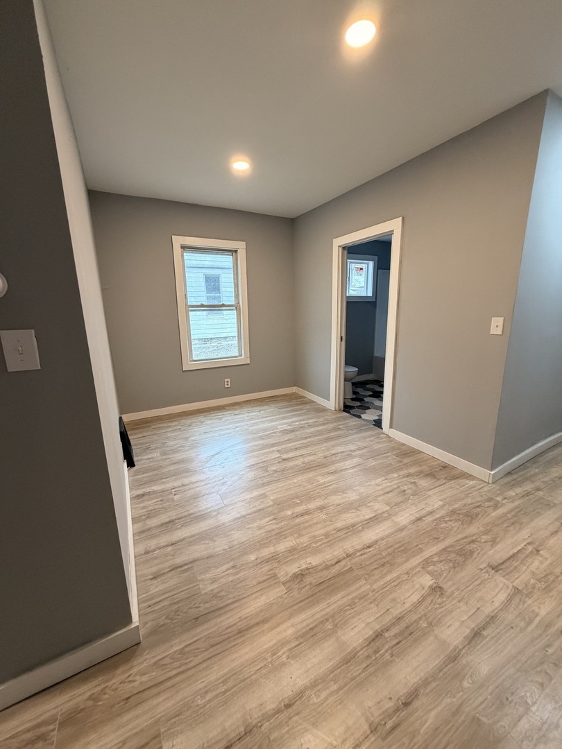 1024 South Warren Street Peoria, IL 61605 - Photo 5 of 14 an empty room with wooden floor and windows
