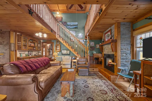 a living room with furniture a fireplace and a chandelier