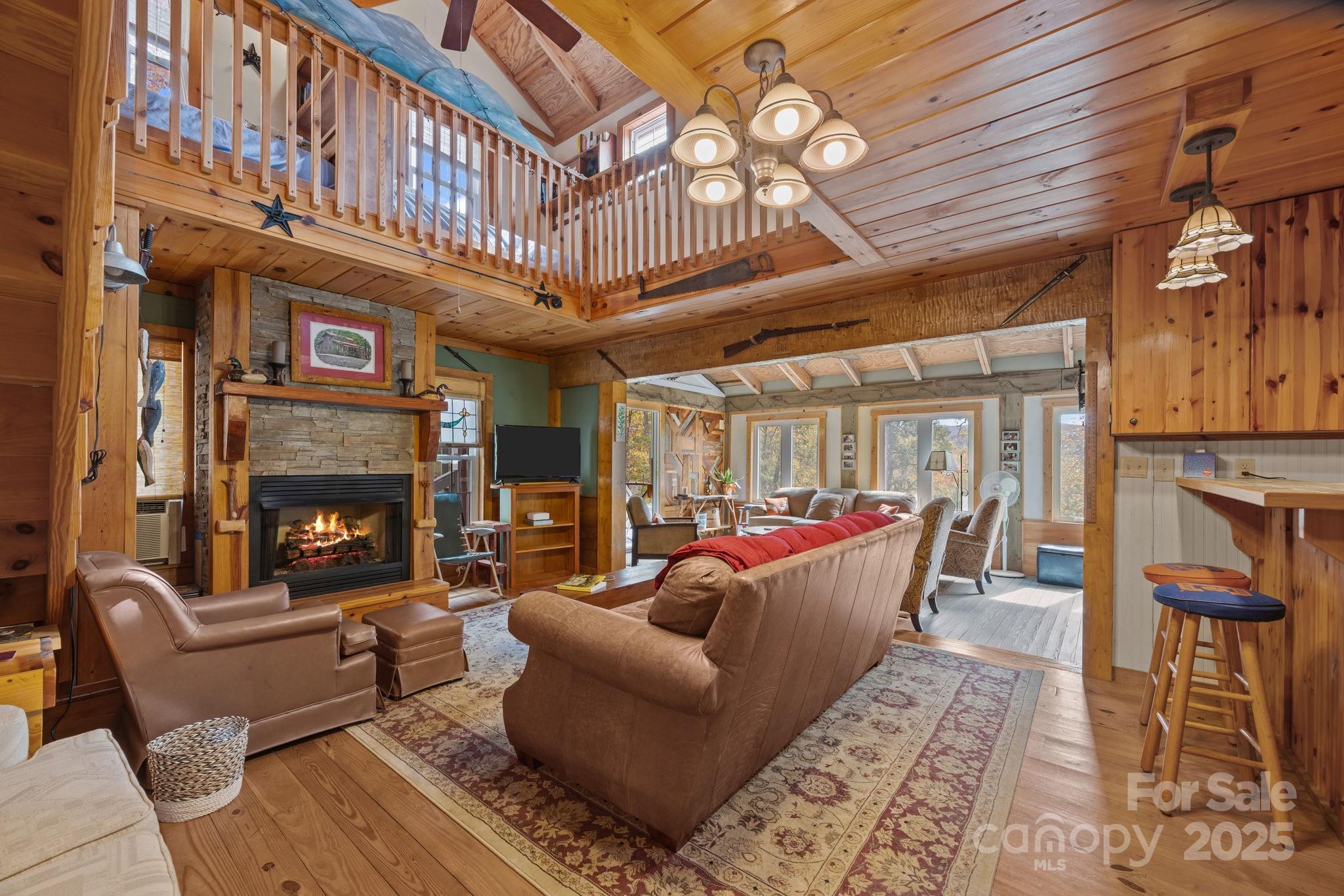 38 Buzzards Rst Trail, Unit 7 Saluda, NC 28773 - Photo 18 of 47 a living room with furniture a fireplace and a chandelier