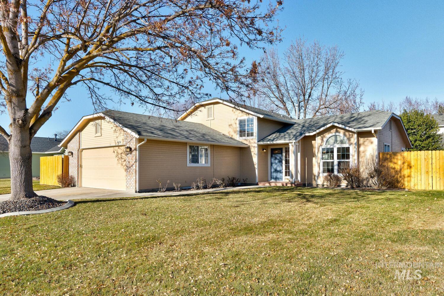 Traditional home with an attached garage, brick siding, concrete driveway, and roof with shingles
