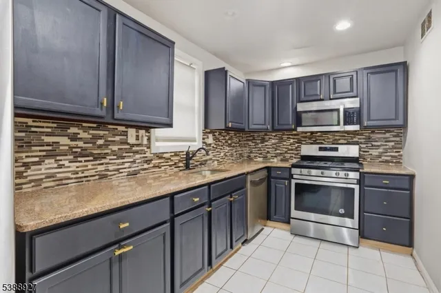 a kitchen with granite countertop a stove sink and cabinets