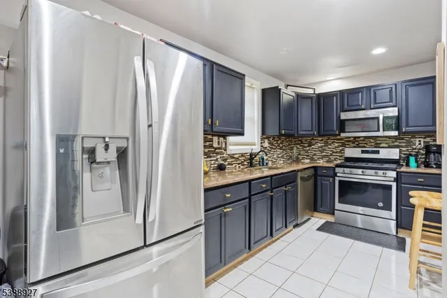 a kitchen with stainless steel appliances a refrigerator sink and cabinets