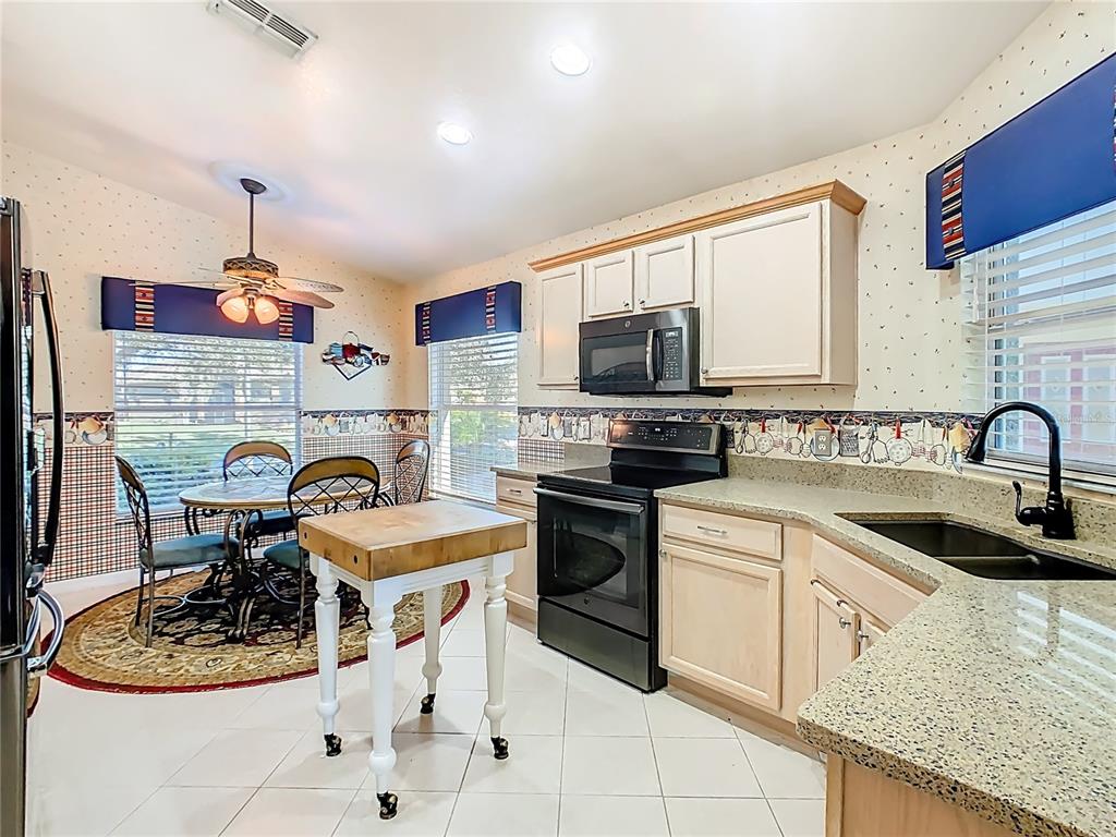 121 Rialto Road Poinciana, FL 34759 - Photo 13 of 68 a kitchen with kitchen island granite countertop a sink appliances cabinets and a counter top space