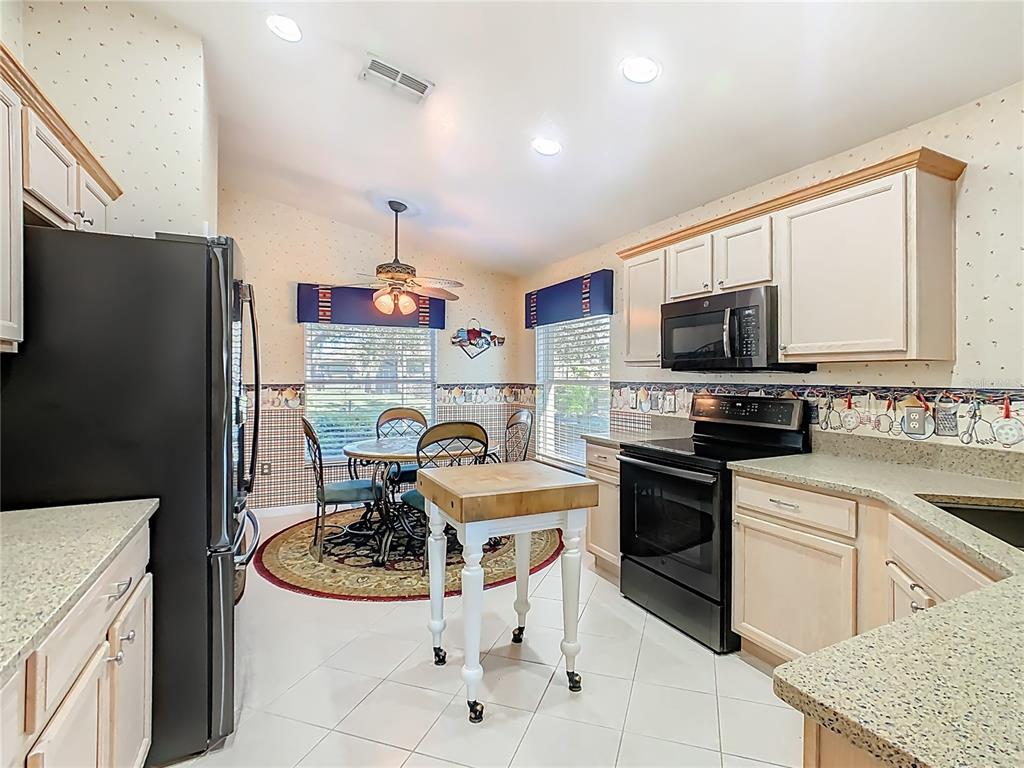 121 Rialto Road Poinciana, FL 34759 - Photo 10 of 68 a kitchen with a sink a stove and chairs