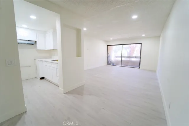 an empty room with white walls and windows