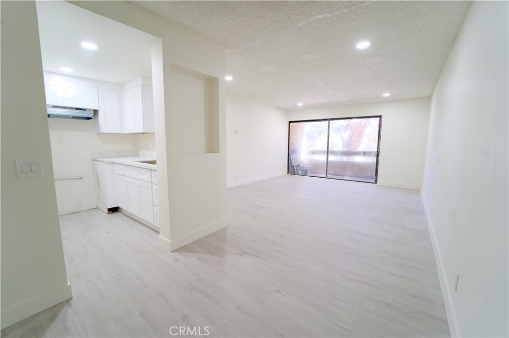 an empty room with white walls and windows