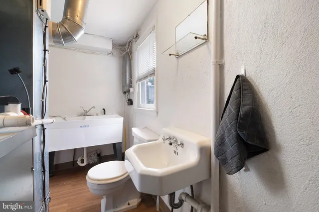 a bathroom with a sink toilet and a mirror