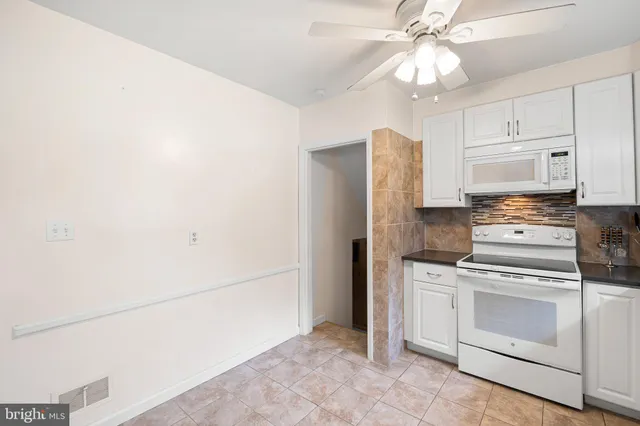 a kitchen with stainless steel appliances white cabinets and white appliances