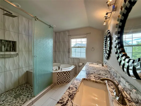 a spacious bathroom with a tub sink and mirror