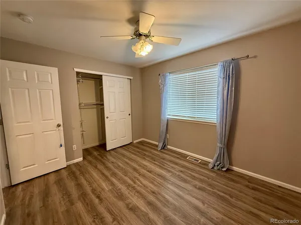 an empty room with closet and windows