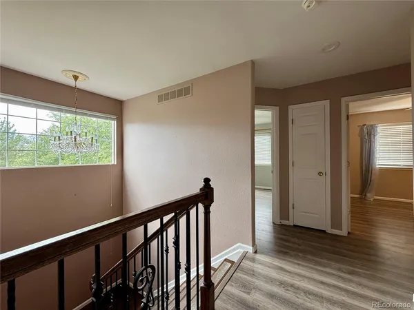 a view of a hallway with wooden floor and staircase