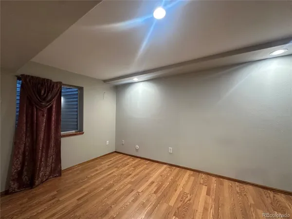 an empty room with wooden floor and a window