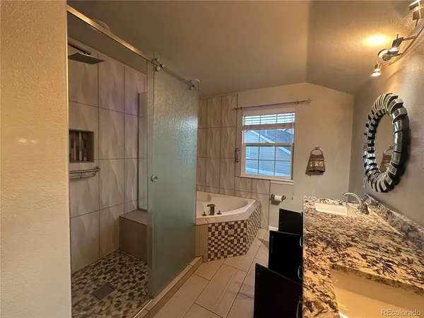 a spacious bathroom with a double vanity sink a mirror and a bathtub
