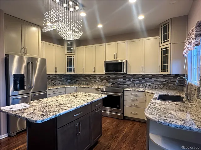 a kitchen with stainless steel appliances granite countertop a sink stove and refrigerator