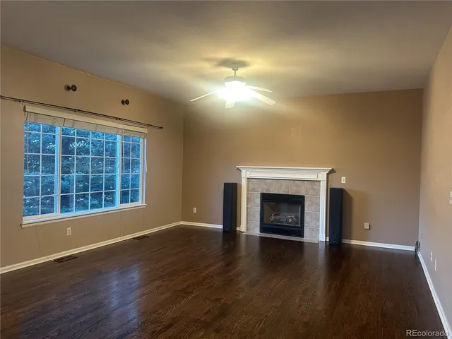 an empty room with windows and fireplace