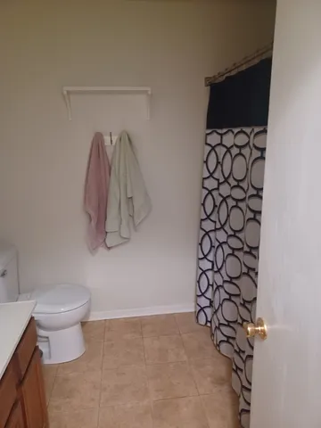 a bathroom with a toilet and a shower curtain