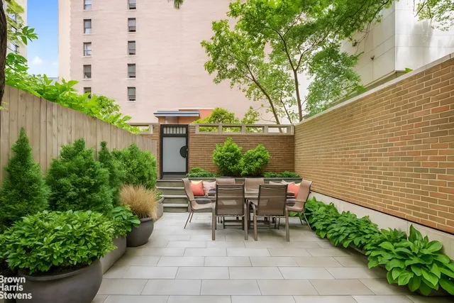a view of backyard with outdoor seating and plants