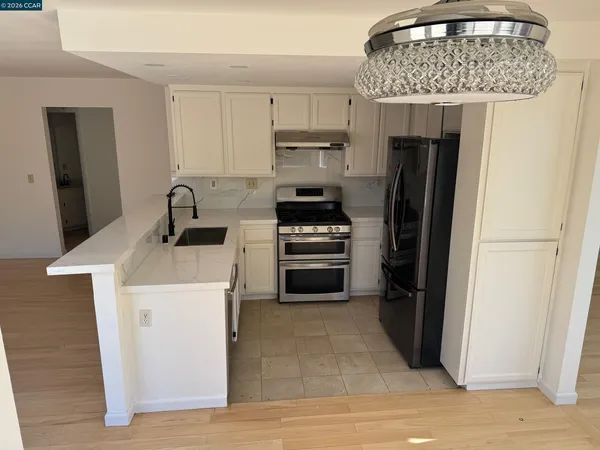 a kitchen with stainless steel appliances granite countertop a refrigerator and a sink