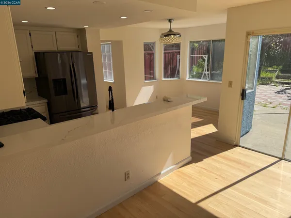a kitchen with stainless steel appliances kitchen island granite countertop a refrigerator and a sink