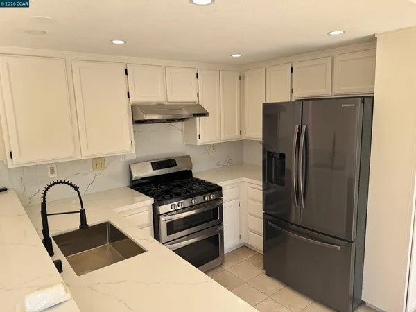 a kitchen with a refrigerator and a stove top oven