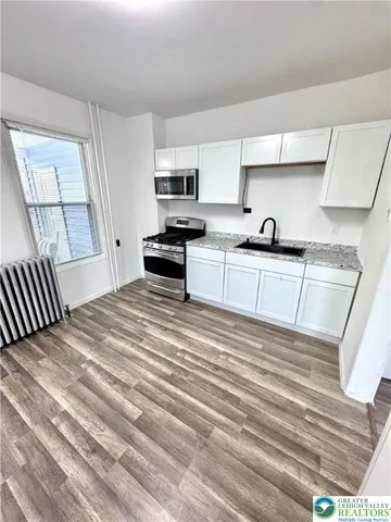 a kitchen with stainless steel appliances granite countertop a sink stove microwave and cabinets