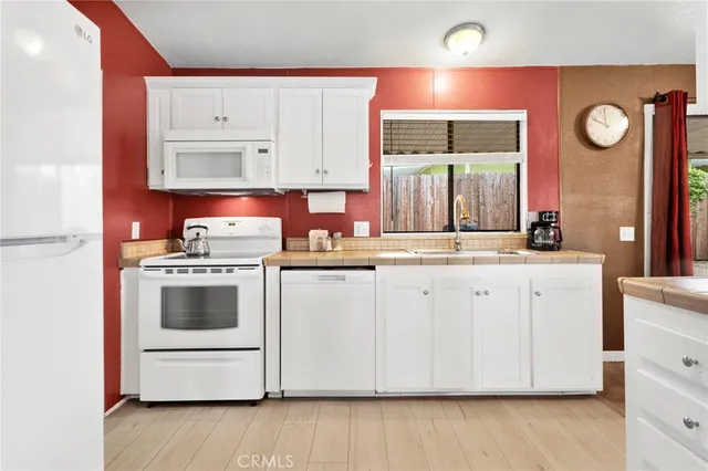 a kitchen with cabinets oven and a clock
