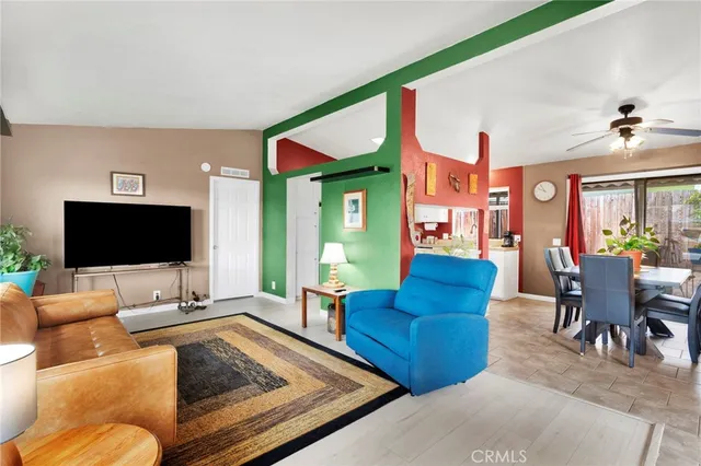 a living room with furniture kitchen view and a large window