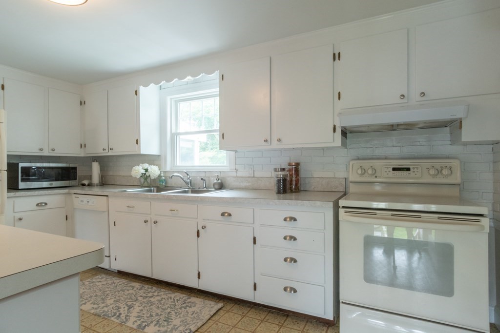 12 Longfellow Road Needham, MA 02494 - Photo 10 of 16 a kitchen with granite countertop white cabinets and white appliances